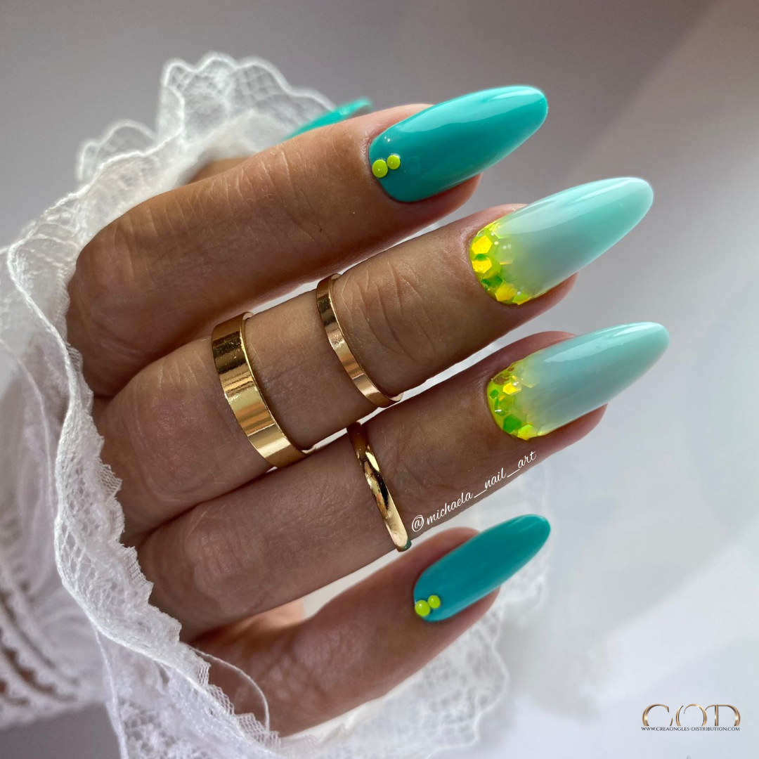 Photo d'une pose d'ongle en amande bleu turquoise avec nail art cuti glitter jaune fluo