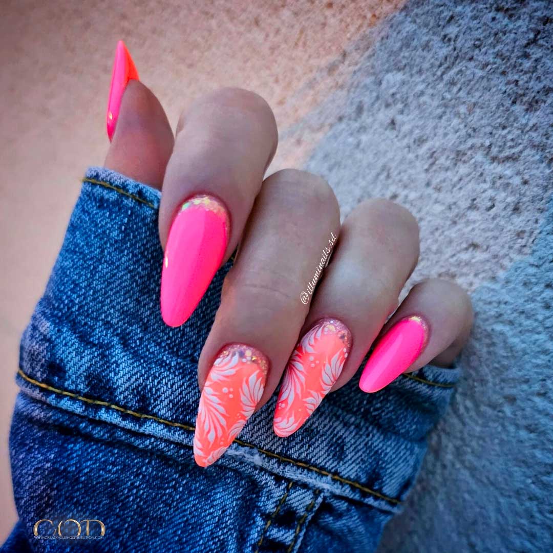 Photo d'ongles rose et corail flashy avec nail art cuti glitter et feuillage