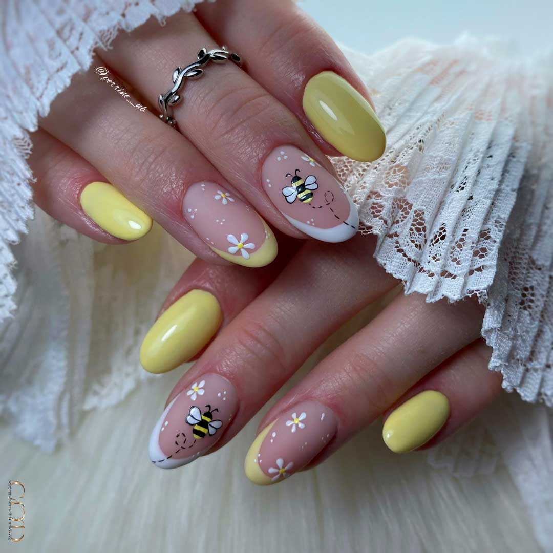 Photo d'ongles ovale court jaunes avec nails art french, abeille et fleurs