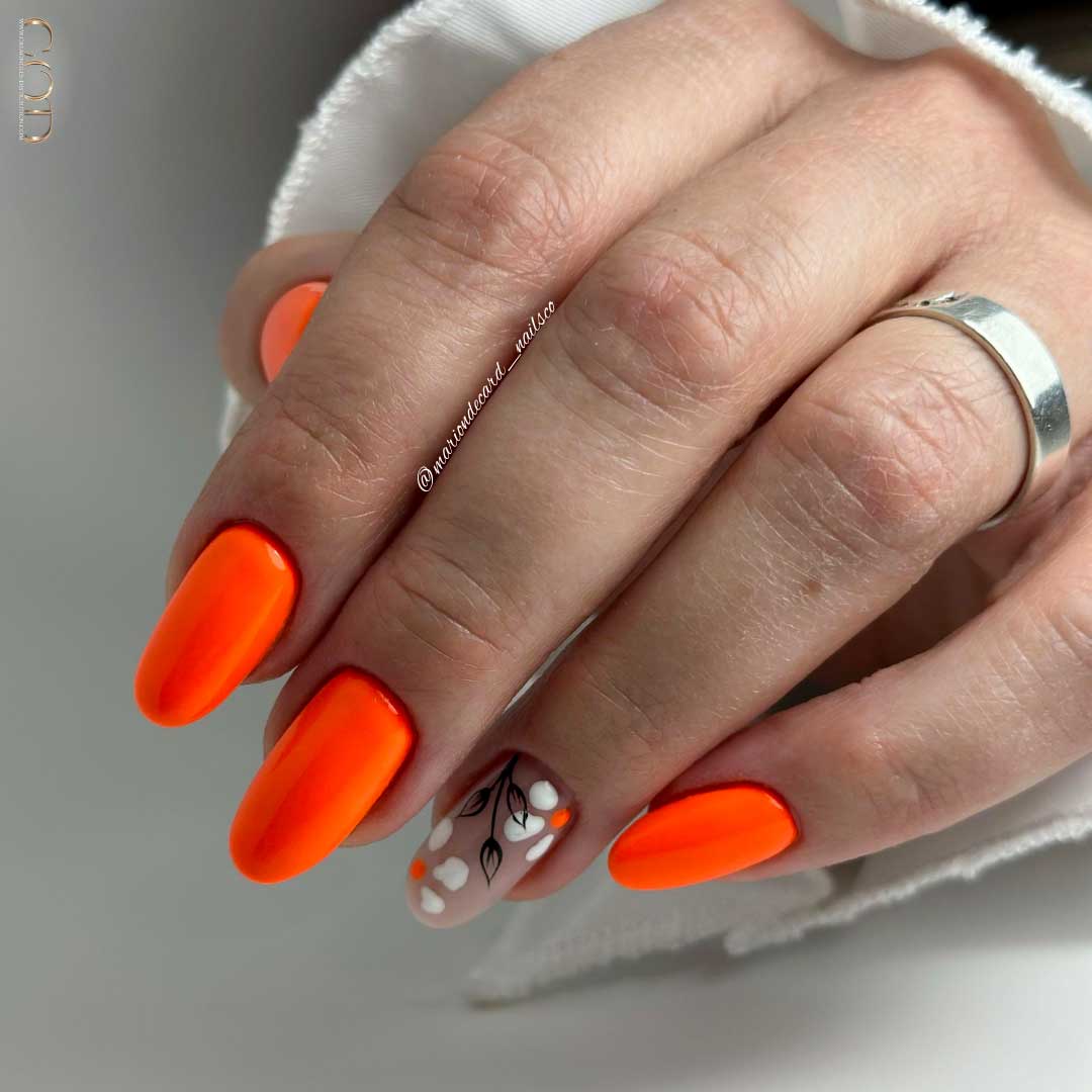 Photo ongles ovale long orange flashy avec nails art fleurs sur l'index