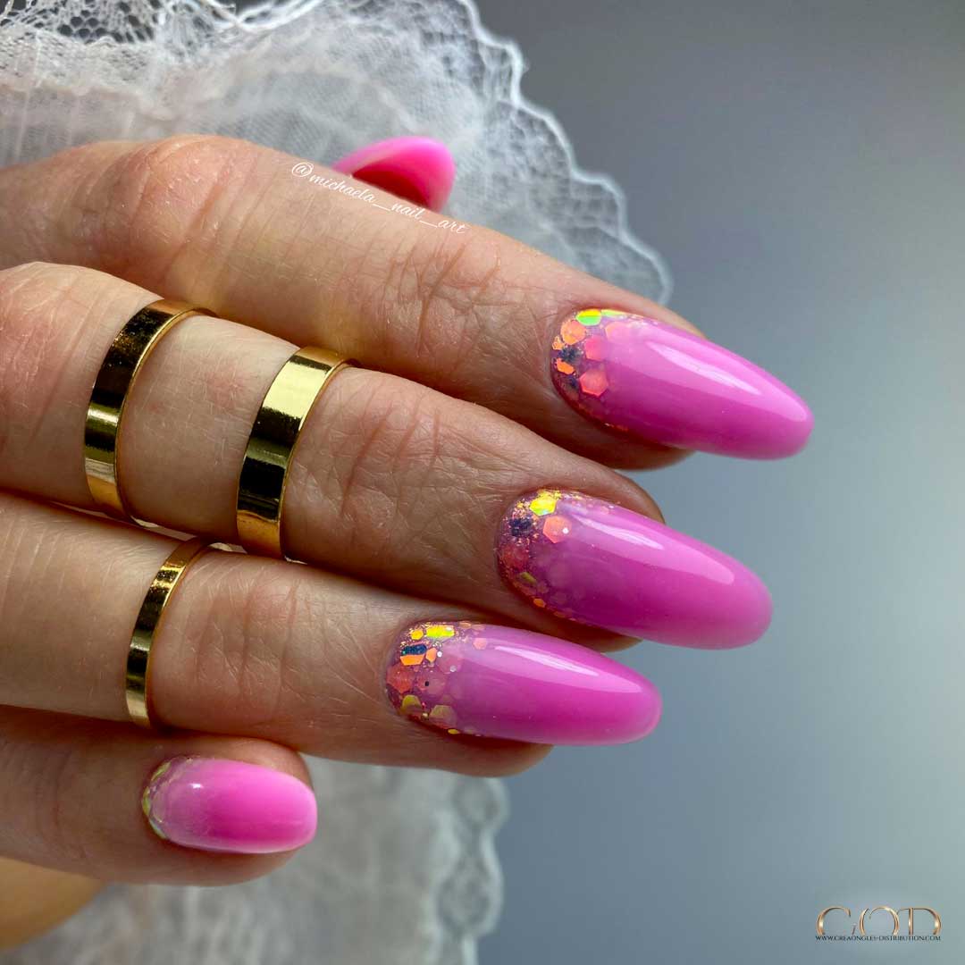 Photo d'une pose d'ongle rose néon avec nail art cuti glitter. 